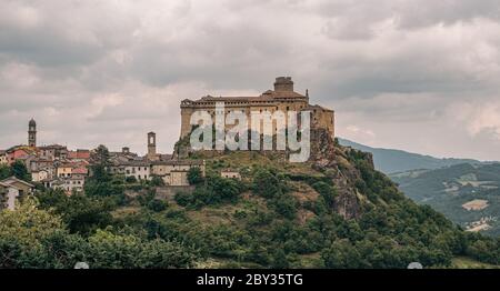 Das Schloss und das Dorf Bardi in einem bewölkten Tag. Parma Provinz, Emilia und Romagna, Italien. Stockfoto