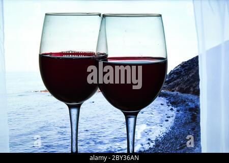 Zwei Gläser Rotwein im Freien auf tropischen Inseln, Kanarischen Inseln, Spanien mit herrlichem blauen Meerblick aus dem Fenster serviert Stockfoto