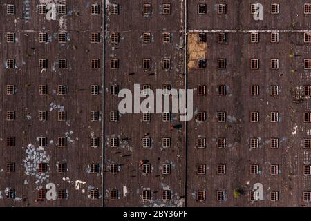 Eine Luftaufnahme eines großen Industriewerksdaches, aufgenommen mit einer Drohne. Abstrakt gestreiftes Muster von Fenstern für Hintergründe Stockfoto