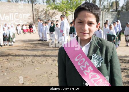 Schüler innerhalb und außerhalb einer Schule in Swat Valley, KPK, Pakistan. Stockfoto