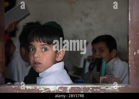 Schüler innerhalb und außerhalb einer Schule in Swat Valley, KPK, Pakistan. Stockfoto