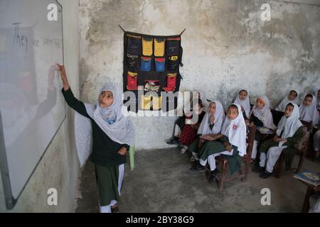 Schüler innerhalb und außerhalb einer Schule in Swat Valley, KPK, Pakistan. Stockfoto