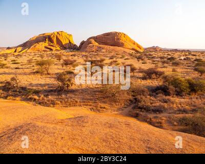 Landschaft um Spitzkoppe, auch Spitzkop genannt, mit massiven Granitfelsen, Namib Wüste in Namibia, Afrika. Stockfoto