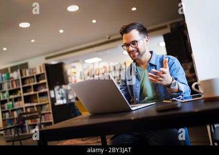 Der Schüler bereitet die Prüfung und den Lernunterricht in der Schulbibliothek vor Stockfoto