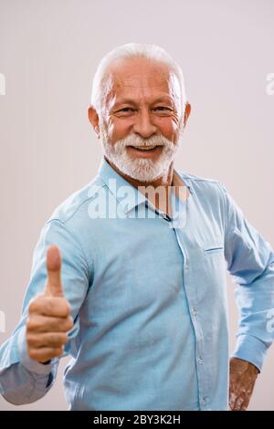 Porträt eines fröhlichen Seniors, der mit der Kamera schaut und lächelt. Stockfoto