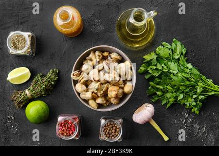 Draufsicht auf Muscheln in Schüssel mit Gewürzen und Kräutern Stockfoto