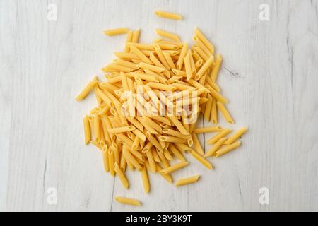 Ansicht von oben auf Penne Pasta auf Holzhintergrund Stockfoto