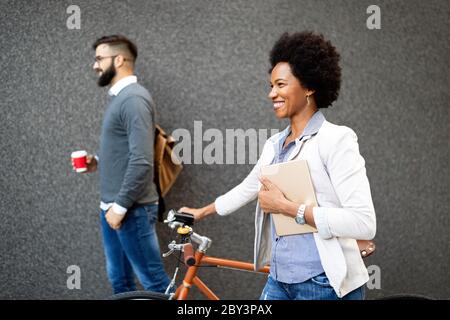 Fröhliche, fröhliche Geschäftsfrau, die mit dem Fahrrad arbeitet Stockfoto