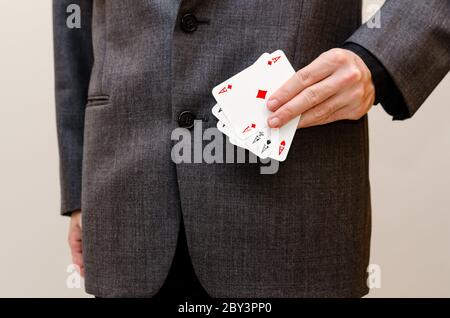 Geschäftsmann hält eine Poker-Karte von Assen in den Händen Stockfoto