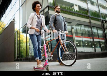 Glückliches Paar mit elektrischem Roller und Fahrrad in der Stadt. Umweltfreundliches Energiekonzept ohne Emissionen Stockfoto