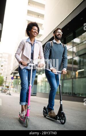 Junges Paar im Urlaub, das Spaß hat, mit dem Elektroscooter durch die Stadt zu fahren. Stockfoto