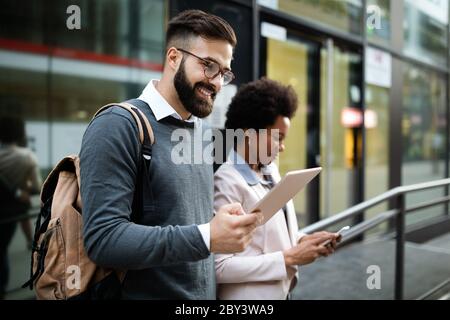Paare, Unternehmen, Technologiekonzept. Geschäftsmann mit Tablet und Frau mit Smartphone im Gespräch Stockfoto
