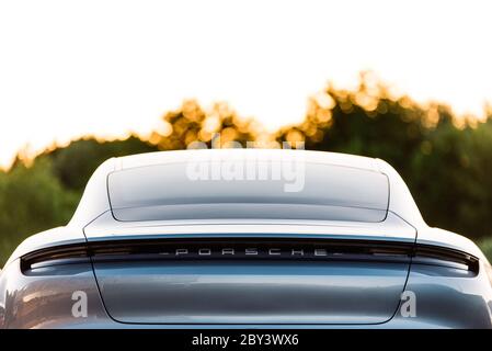 Alesund / Norwegen - 31. Mai 2020: Silberne Porsche Taycan Limousine auf einem Parkplatz, zu Werbezwecken geparkt. Außenansicht mit Details. Stockfoto