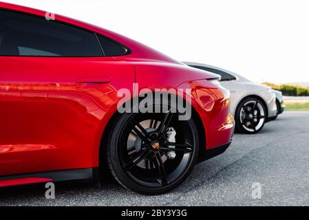 Alesund / Norwegen - 31. Mai 2020: Drei luxuriöse Porsche Taycan Limousinen auf einem Parkplatz, für Werbezwecke geparkt. Stockfoto