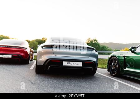 Alesund / Norwegen - 31. Mai 2020: Drei luxuriöse Porsche Taycan Limousinen auf einem Parkplatz, für Werbezwecke geparkt. Stockfoto