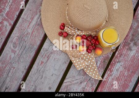 Ein Glas tropischer exotischer Multifruitsaft und Früchte am Pier. Tropisches Picknick am Strand Stockfoto