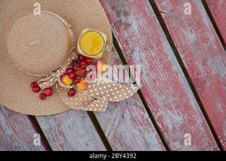 Ein Glas tropischer exotischer Multifruitsaft und Früchte am Pier. Tropisches Picknick am Strand Stockfoto