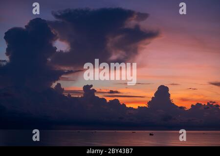 Landschaft Sonnenaufgang auf der Insel Phu Quoc, Vietnam. Reise- und Naturkonzept. Morgenhimmel, Gewitterwolken, Fischerboot und Meerwasser Stockfoto