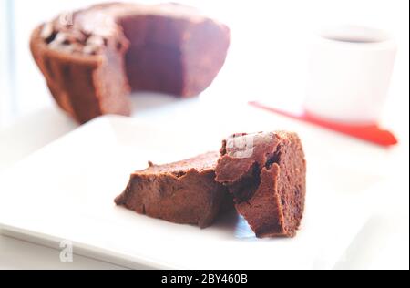 Nahaufnahme Seitenansicht von gestapelten trockenen Brownies und defokussierten Kaffee mit hellen eleganten weißen Farben Stockfoto