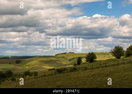 Blick von der Spitze des Morgans Hill mit Blick auf ein sonnenbeschienene Lansdowne Monument und Calstone und Cherhill Downs, Wiltshire England, Großbritannien. Stockfoto