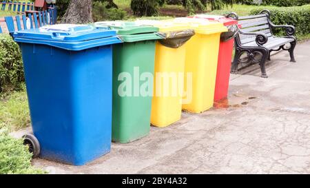 Separate Container für die Müllabfuhr im Park. Bunte Straßenabfallbehälter auf der Straße. Behälter Selektive Sammlung von Abfällen. Envir Stockfoto