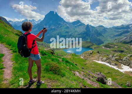 Wanderfrau, die ein Foto von Pic du Midi Ossau in den französischen Pyrenäen gemacht hat Stockfoto