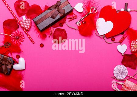 Tabelle top Ansicht Bild der Dekoration valentinstag Hintergrund Konzept. Flache Lay-Anordnung aus roter Form & Geschenkbox mit wesentlichen Artikeln auf modernen Pas Stockfoto