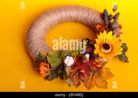 Handgefertigter Kranz aus kleinen Kürbissen und Blumen an einer Vintage-Tür Stockfoto
