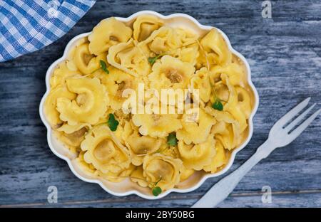 Tortellini Italienische gefüllte Pasta auf einem Teller mit Käse und Gemüse Stockfoto