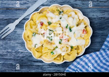 Tortellini Italienische gefüllte Pasta auf einem Teller mit Käse und Gemüse Stockfoto