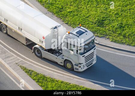 Leistungsstarker schwerer weißer LKW mit Tank für brennbare Flüssigkeiten fährt auf der Straße, Luftaufnahme von vorne Stockfoto