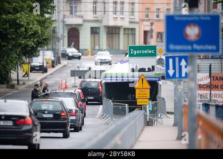 09. Juni 2020, Sachsen, Görlitz: Polnische Grenzposten stehen auf der Brücke der Freundschaft an der polnischen Grenze vor Zgorzelec und prüfen mit einem Thermometer die Körpertemperatur der Fahrer, die aus Gorlitz nach Polen kommen. Foto: Sebastian Kahnert/dpa-Zentralbild/dpa Stockfoto