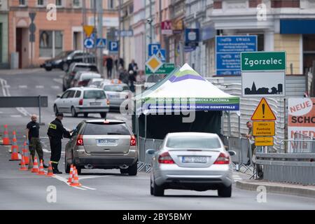 09. Juni 2020, Sachsen, Görlitz: Polnische Grenzposten stehen auf der Brücke der Freundschaft an der polnischen Grenze vor Zgorzelec und prüfen mit einem Thermometer die Körpertemperatur der Fahrer, die von Gorlitz nach Polen kommen. Foto: Sebastian Kahnert/dpa-Zentralbild/dpa Stockfoto