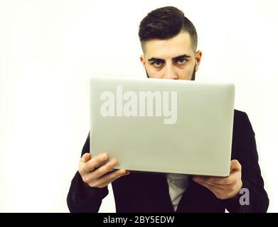 Erfolgreicher Geschäftsmann mit ernsthaftem Look hält weißen Laptop in den Händen, isoliert auf weißem Hintergrund. Idee der Geschäftstechnologie Stockfoto
