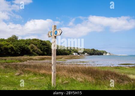 Küstenpfad Wegweiser auf Seeufer Salzmarsch in Red Wharf Bay, Isle of Anglesey, Wales, Großbritannien Stockfoto