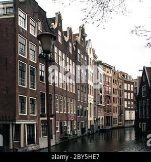 Typischer Wasserkanal - Gracht - und enge Häuser entlang in Amsterdam Stadtzentrum, Niederlande Stockfoto