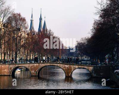 Gracht oder Canal of Amsterdam mit typischer niedriger Brücke im Frühfrühling, Niederlande Stockfoto