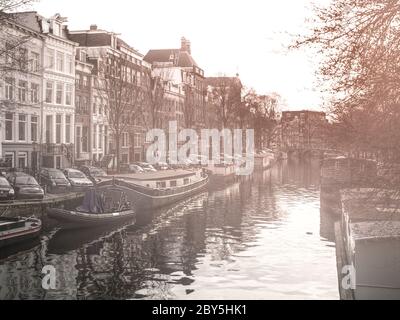 Morgennebel am Wasserkanal, Gracht, in Amsterdam, Niederlande Stockfoto