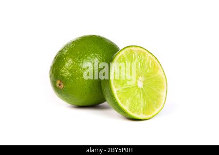Eine ganze Limette und eine halbe Limette auf weiß Stockfoto