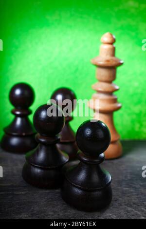 Makro-selektiver Fokus Foto von schwarzen Schachfiguren auf grünem Hintergrund Stockfoto