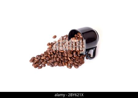 Verschüttete Kaffeebohnen aus der schwarzen Keramikschale isoliert auf weißem Hintergrund. Ideal für Kaffee-Menü. Stockfoto