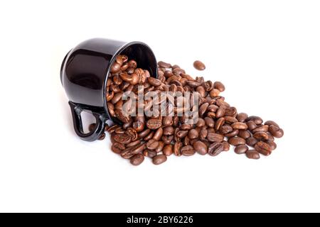Verschüttete Kaffeebohnen aus der schwarzen Keramikschale isoliert auf weißem Hintergrund. Ideal für Kaffee-Menü. Stockfoto