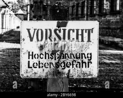 Warntafel am elektrischen Zaun im Konzentrationslager Oswiecim, Polen. Schwarzweiß-Bild. Stockfoto