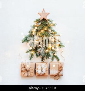 Null Abfall Weihnachtskonzept. Weihnachtsbaum aus natürlichen Tannenzweigen mit Holzstern und Papier Spitze Geschenk gemacht. Stockfoto