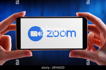 POZNAN, POL - 21. MAI 2020: Hände halten Smartphone mit Logo von Zoom, Videotelefonie und Online-Chat-Dienste über eine Cloud-basierte Peer-to-pe Stockfoto
