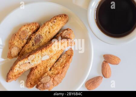 Frisch gebackene italienische Cantucci mit Mandeln und einer Tasse Kaffee. Toskanische Biscotti. Traditionelle Cantuccini. Hausgemachte italienische Süßigkeiten Kekse (Kekse). Stockfoto