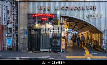 Leute, die in der Hintergasse des Yurakucho-Bezirks, Tokio, Japan bei Nacht spazieren gehen. Stockfoto