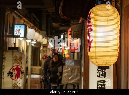 Leute, die in der Hintergasse des Yurakucho-Bezirks, Tokio, Japan bei Nacht spazieren gehen. Stockfoto