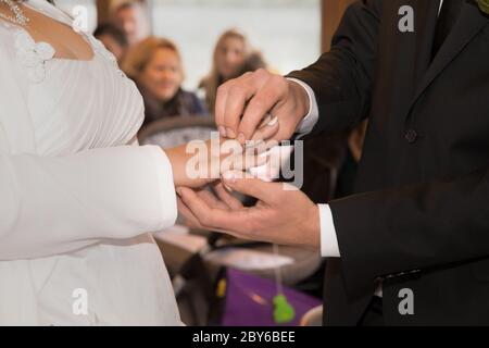 Das Brautpaar tauscht die Eheringe miteinander aus Stockfoto