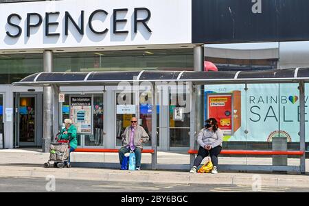 Brighton UK 9. Juni 2020 - Einkäufer an einer Bushaltestelle in Brighton, da mehr nicht notwendige Geschäfte und Cafés sich darauf vorbereiten, während der Lockdown-Beschränkungen in der Coronavirus COVID-19 Pandemie-Krise wieder zu öffnen. Quelle: Simon Dack / Alamy Live News Stockfoto